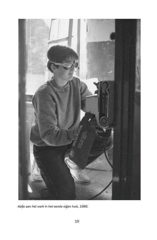 Een jongen met veiligheidsbril en handschoenen knielt en gebruikt een schuurmachine.