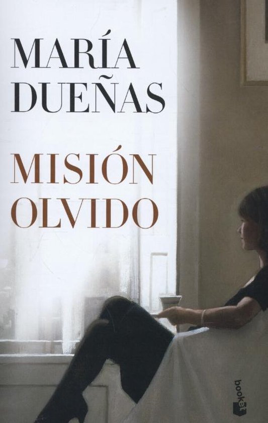 Livre 'Misión Olvido' de María Dueñas. Une femme est assise près d'une fenêtre, regardant dehors.