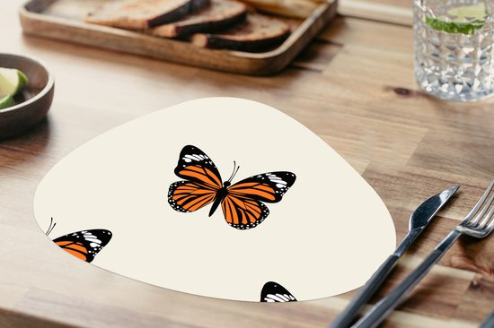 Crèmekleurige placemat met oranje vlinderprint, met bestek en brood op een houten tafel.