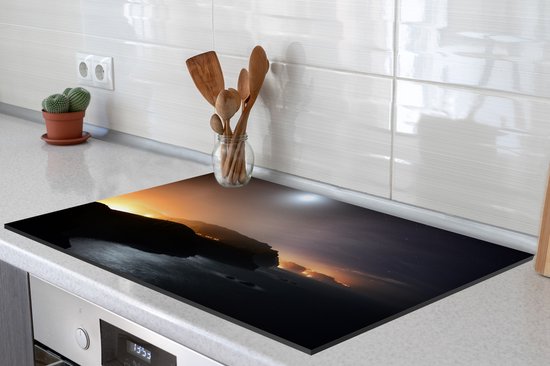 KitchenYeah® Inductie beschermer 78x52 cm - Stadslichten schijnen in de nacht van Madeira langs het zeewater - Kookplaataccessoires - Afdekplaat voor kookplaat - Inductiebeschermer - Inductiemat - Inductieplaat mat
