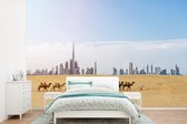Behang - Fotobehang Kamelen die in de woestijn voor Dubai langslopen - Breedte 360 cm x hoogte 240 cm