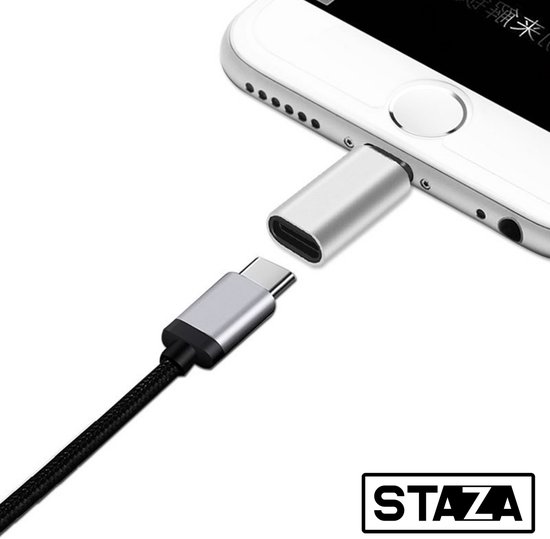 Adaptateur USB-C vers Lightning argenté, connecté à un smartphone avec un câble rayé.