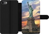 Bookcase Geschikt voor iPhone 7 telefoonhoesje - Vrijheidsbeeld in New York tijdens zonsondergang - Met vakjes - Wallet case met magneetsluiting