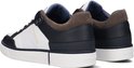 Zijkant van twee witte sneakers met marineblauwe en bruine accenten, met 'G-STAR RAW' op de zijkant.