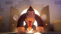 Donkey Kong met een rode stropdas staat dreigend in een deuropening met fel licht achter hem.