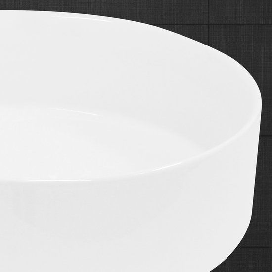 Detailopname van de ronde, witte keramische waskom.