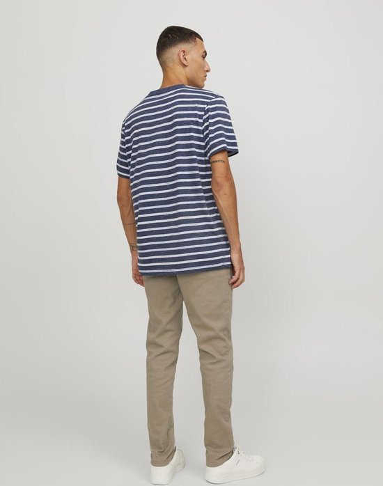 Man met gestreept blauw-wit T-shirt en beige chino broek, de achterkant zichtbaar.