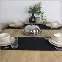 Gedekte tafel met beige servies, zwart tafelkleed en een zilveren dekselhouder.