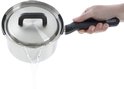 Een hand giet water uit een zilverkleurige steelpan met zwarte handvatten.