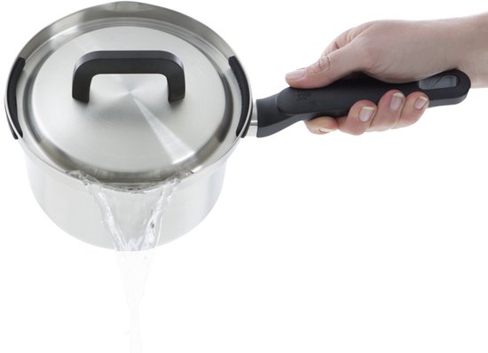 Een hand giet water uit een zilverkleurige steelpan met zwarte handvatten.