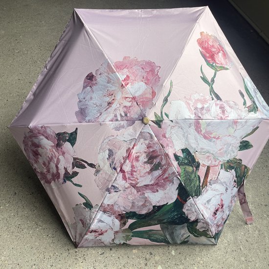 Zespanelen paraplu, gesloten, met een fel roze pioenrozen schilderijprint op een lichtere roze achtergrond.