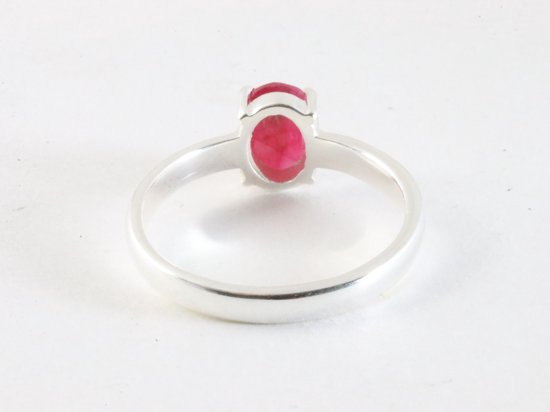 Zilveren ring met ovale, helderrode robijn, van de achterkant bekeken. De ring heeft een hoogglans afwerking.