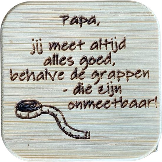 Houten meetlint met de tekst 'Papa, jij meet altijd alles goed, behalve dé grappen - die zijn onmeetbaar!' en een tekening van een rolmaat.