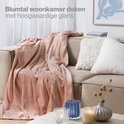 Oud roze Blumtal woondeken met hoogwaardige glans, gedrapeerd over een bank.
