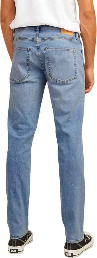 Achterkant van een man met lichte wassing jeans aan.