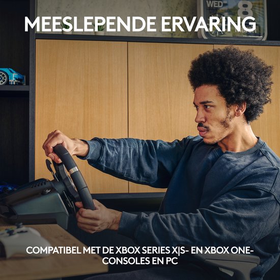 Man met afro zit op een racestoel en speelt op een racestuur dat compatibel is met Xbox Series X|S en pc.
