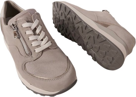Grijze sneaker met rits en witte veters, met zool zichtbaar. Zijaanzicht.