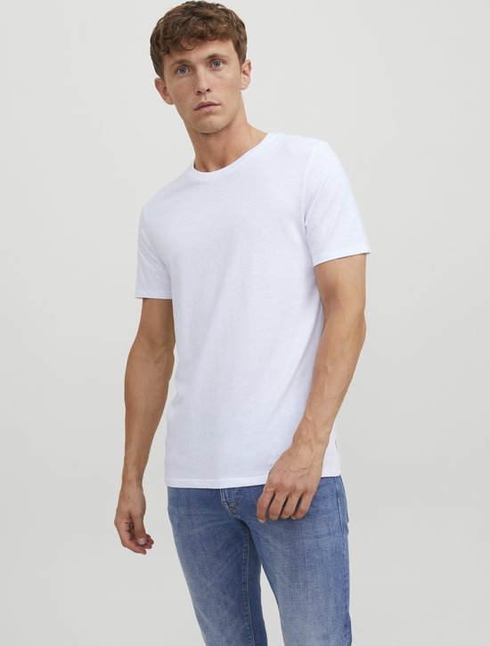 Man met korte mouwen, ronde hals, witte T-shirt en blauwe jeans.