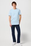 Man draagt een lichtblauwe T-shirt met korte mouwen en donkerblauwe jeans.