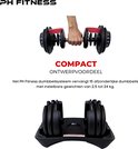 Hand houdt een zwarte verstelbare dumbbell vast; de set staat op een zwart rek.