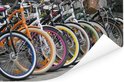 Une rangée de vélos aux jantes colorées vives: orange, bleu, blanc, rose, jaune, vert, marron, blanc.