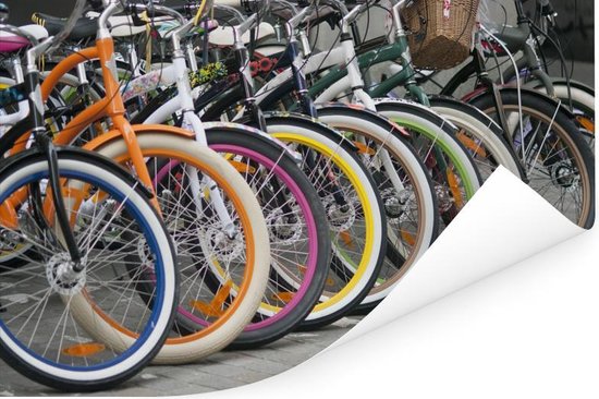 Une rangée de vélos aux jantes colorées vives: orange, bleu, blanc, rose, jaune, vert, marron, blanc.