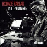Horace Parlan à Copenhague, le pianiste avec lunettes et casquette joue du piano, avec le logo Storyville.