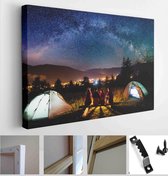 Fellow hikers are sitting on a bench made of logs and watching the fire together at night near campsites and tents - Modern Art Canvas - Horizontal - 587557163 - 115*75 Horizontal