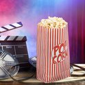 Popcornzakje met rode en witte strepen naast een filmklapper en filmrol.