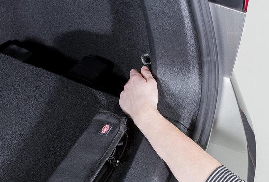 Hand bevestigt een karabijnhaak aan een oog in de kofferbak van een auto om de bumperbeschermer te bevestigen.