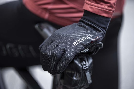 Hand in zwarte Rogelli fietshandschoen met logo, op een fiets.