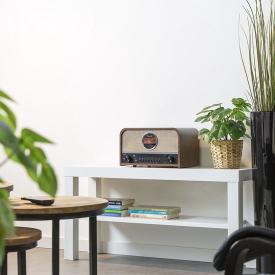 Audizio Salerno radio met CD-speler op een witte console, omringd door planten en meubels.