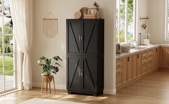 Zwarte voorraadkast met vier schuurdeuren, in een lichte, moderne keuken met een plant en raam.