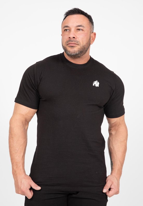 Man met gespierde armen draagt een zwart t-shirt met Gorilla Wear logo op de borst.