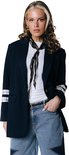 Vrouw met blond haar, draagt donkerblauw pinstripe colbert met kanten details, wit T-shirt en lichte jeans met sterren.