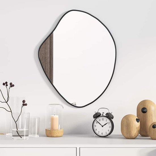 Onregelmatige zwarte spiegel met houten accent, 50x40 cm. Staat op een witte kast met decoraties.