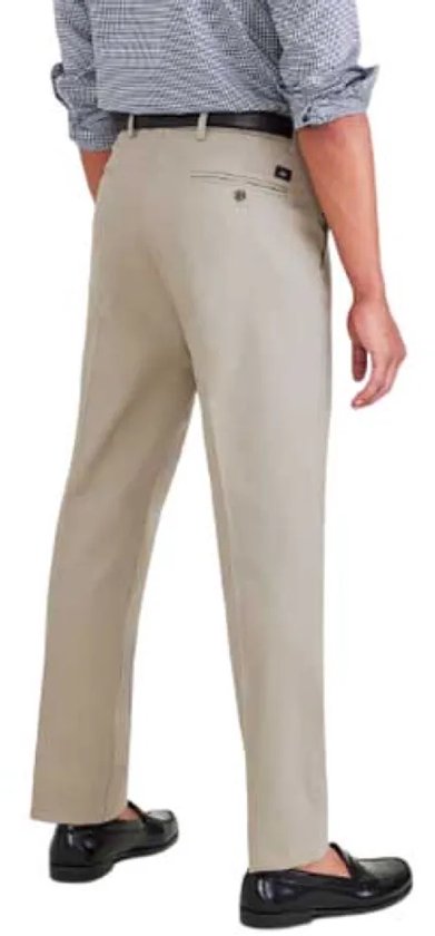 Man in beige Dockers broek, linkerzij zichtbaar. Gekleed in geruit overhemd en zwarte schoenen.