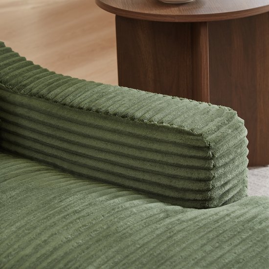 Detail van de groene corduroy stof van de armleuning van de fauteuil.