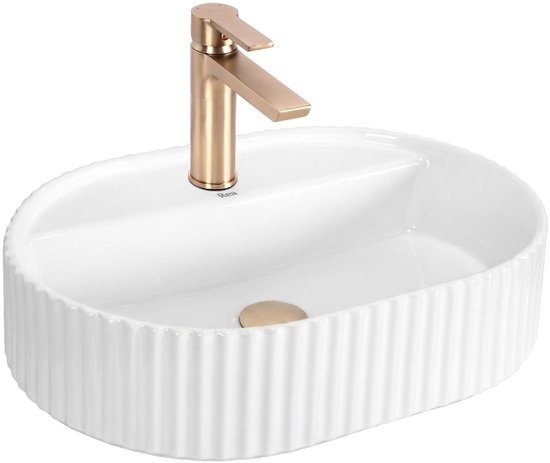 Lavabo ovale blanc à bord côtelé et robinet doré sur fond blanc.