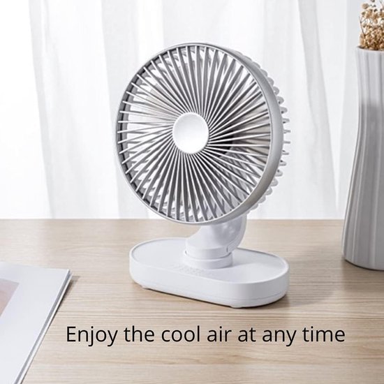Compacte witte tafelventilator met grijze grill, geplaatst op een houten bureau.