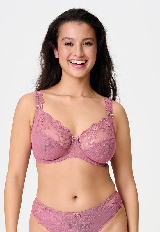 Vooraanzicht van een lachend model in een oudroze LingaDore beugelbeha met kant en een bijpassende slip.
