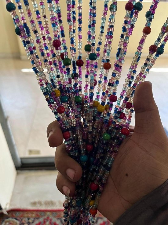 Une main tient plusieurs guirlandes de perles multicolores : violet, bleu, rose, vert et jaune.