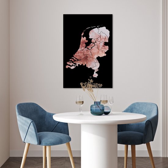 Affiche des Pays-Bas en teintes rose délavé avec bordure noire, suspendue à un mur blanc au-dessus d'une table ronde.