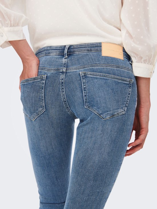 Detail van de achterkant van een lichtblauwe skinny jeans met twee achterzakken.