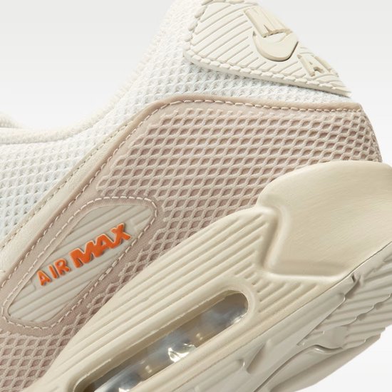 Close-up van de hiel en zijkant van een witte Nike Air Max 90 sneaker met beige en bruine details.