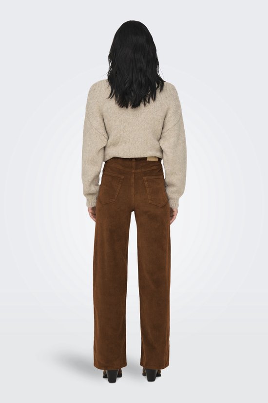 Achterkant van model in bruine corduroy broek met wijde pijpen en beige trui.