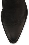 Close-up van de spitse neus van een zwarte nubuck cowboylaars.