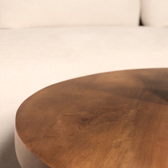 Gedetailleerde close-up van het walnootkleurige mangohouten tafelblad van een ronde salontafel.