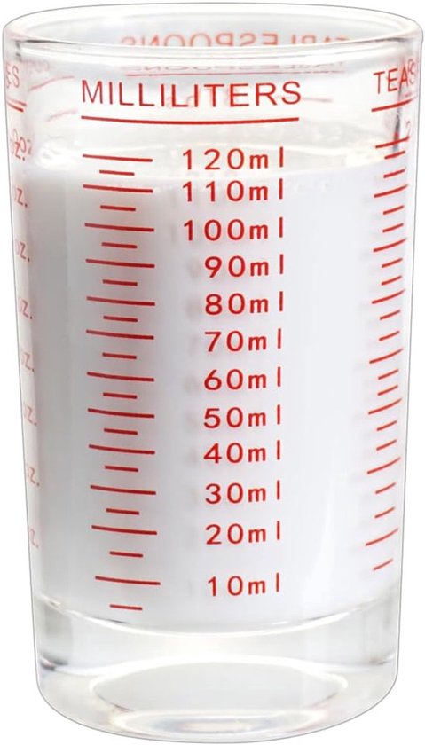 Verre doseur en verre de 120 ml rempli de lait, avec des graduations rouges.