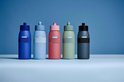 Cinq bouteilles Mepal Ellipse bleues, bleu clair, roses, vertes et noires, avec une bande et un bouchon gris.